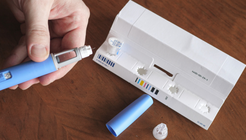 A man prepares his GLP-1 agonist medication injector for his weekly weight loss injection.