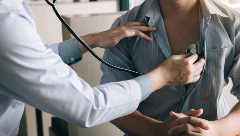 A doctor uses a stethoscope to check a patient’s heartbeat during an executive physical.