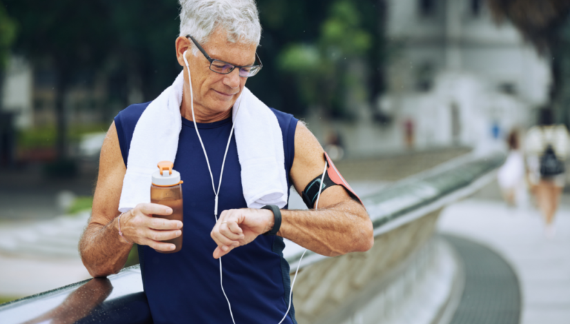 A senior man checking his smartwatch after a workout, illustrating active aging with Iollo.