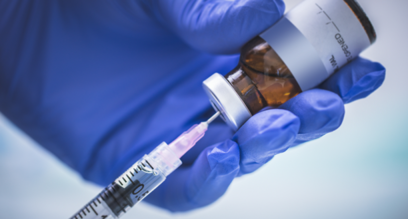 A gloved hand prepares the trivalent vaccine for this year’s flu season.