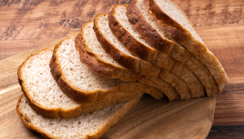 Freshly sliced white bread loaf arranged on wooden cutting board.