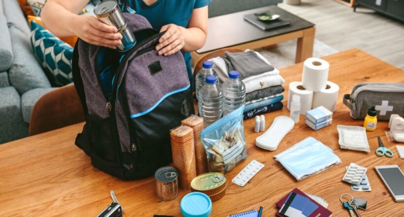 Person packing a bag with essential items like toiletries, clothing, and entertainment for an overnight hospital stay.