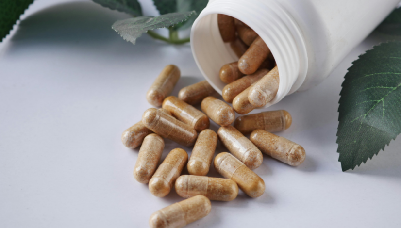Golden-brown herbal supplement capsules spilling from a white bottle, illustrating berberine benefits.